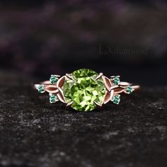 a ring with an oval green stone surrounded by emeralds and white diamonds on a black surface