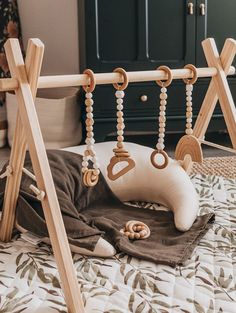 a baby crib with wooden toys hanging from it's sides and on the ground