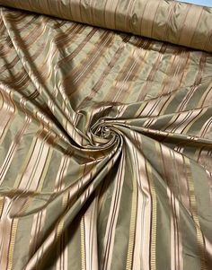 a close up view of a bed with a brown and tan striped comforter on it