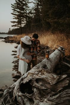 a man and woman standing next to each other near the water