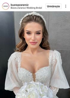 a woman wearing a wedding dress and holding a bridal bouquet in front of her face