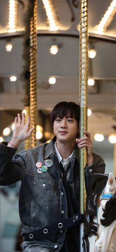 a young man riding on the back of a merry go round