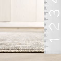 a ruler is on the floor next to a rug