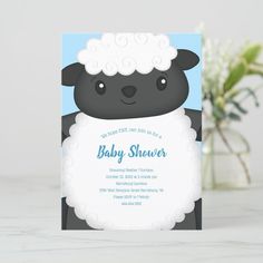 a baby shower card with a black sheep holding a white sheet in it's mouth