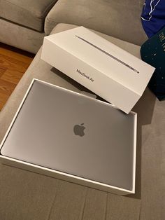 an apple macbook pro with its box opened on the floor next to it's packaging