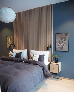 a bedroom with blue walls and wooden slats on the headboard is pictured in this image