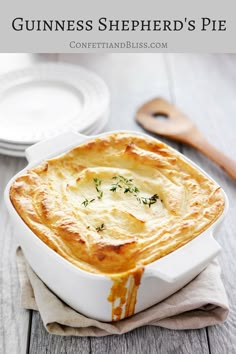 a white dish filled with food on top of a wooden table