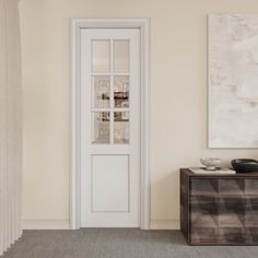 an empty room with a white door and two black vases on the side table