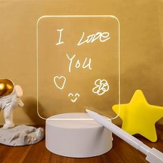 an illuminated sign that says i love you next to a small toy elephant and star