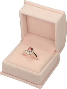 an open pink ring box with a white diamond in it