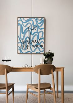 a table with two chairs and a painting on the wall