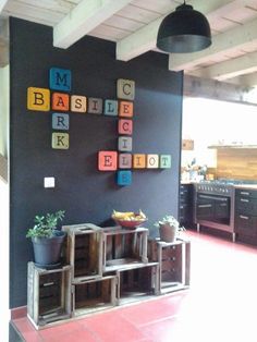 a kitchen with black walls and red tile flooring is decorated with colorful blocks that spell out the word abc