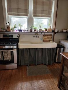 a kitchen with an old fashioned sink and stove in it's center, surrounded by wooden floors