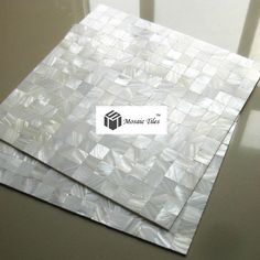 two pieces of white mosaic tile sitting on top of each other