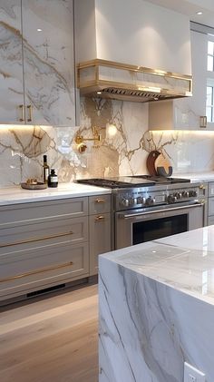 a kitchen with marble counter tops and gold trimmings on the oven, stove hood, and cabinets