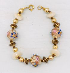 "Cute handmade vintage Venetian bracelet. The lampwork beads are decorated with aventurine swirls, blue dots and pink flowers. This style is called \"fiorato\" (in Italian fiore means flower) or \"wedding cake\" . ✔️ Length: 21 cm. This corresponds to a normal 19 cm. To compensate the diameter of the beads, the bracelet had to be a bit longer. ✔️ Shape glass beads: round 13 mm. The glass spacer beads are also Murano glass! ✔️ Color: cream ✔️ Decoration: flowers, dots, aventurine ✔️ Techniques: l Adjustable Bracelets With Bead Caps For Gift, Adjustable Bracelets With Bead Caps As Gift, Adjustable Murano Glass Beaded Bracelets With Round Beads, Adjustable Murano Glass Beaded Bracelets, Vintage Spacer Beads Bracelets Gift, Vintage Glass Bracelets With Colorful Beads, Vintage Pearl Bracelet With Round Beads For Gift, Vintage Pearl Bracelet With Round Beads As Gift, Vintage Bracelets With Round Spacer Beads