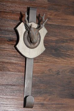 a metal deer head mounted to a wooden door handle on a wood flooring board