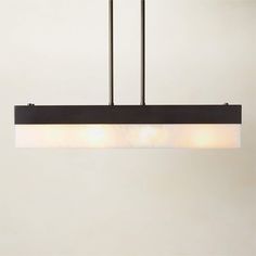 a rectangular light fixture with three lights hanging from the ceiling