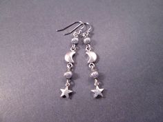 Silver star charms (6mm) and 6x9mm crescent moons, with silver accent beads and french hook ear wires. These earrings measure just under two and 1/4 inches in length.... See more of my designs here; justEARRINGS.etsy.com More Moon/Sun/Star earrings here: https://www.etsy.com/shop/justEARRINGS?ref=simple-shop-header-name&listing_id=98153476&section_id=38062962 And please visit my sister~shops; justCHARMING.etsy.com & BohoDreamJewelry.etsy.com All of my jewelry shops offer FREE SHIPPING! Highlight Black Art Prints, Moon Sun Star, Star Earrings Silver, Silver Star Earrings, Moon And Star Earrings, Crescent Moon Earrings, Crescent Moon Pendant, Moon Sun, Silver Dangle Earrings