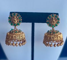 Shop our gorgeous green kemp stone temple jhumka earrings.  Perfect for weddings and parties! Will look best with Indian attire such as sari, lehenga, kurta, suit, etc.         Material: Pure Brass Makes an ideal gift for her and loved ones.  Care Instructions: Clean with a dry cloth. Avoid extreme heat and harsh chemicals such as perfume, deo, hairspray, etc.  Usually arrives within 3-5 business days for US domestic shipping Green Kemp Stone Jhumka Earrings, South Indian Style Temple Jhumka Earrings, Gold Temple Earrings, South Indian jewelry, Temple Jewelry, elephant earrings, gold earrings, Indian Earrings, Traditional jewelry, Green Jewelry, Green Stone, Green Jhumka Earrings, Green Jhumka, Green Jhumki, Gold Jhumka Green Temple Jewelry Jhumkas For Wedding, Green Cutdana Jhumkas For Celebration, Celebration Green Cutdana Jhumkas, Green Jhumkas For Festivals And Celebrations, Festive Green Temple Jewelry Jhumkas, Festive Green Jhumkas With Intricate Design, Green Temple Jewelry Chandbalis With Latkans, Green Temple Jewelry Earrings With Latkans, Green Meenakari Temple Jewelry Jhumkas