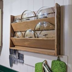 a wooden shelf filled with glassware and plates on top of a green countertop