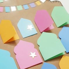 paper cut out to look like houses and stars on a piece of cardboard with colored papers