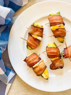 air fryer bacon wrapped jalapeno poppers on a plate next to a blue napkin. Wrapped Jalapeno Poppers, Raspberry Chipotle Sauce, Christmas Finger Foods, Air Fryer Bacon, Bacon Crisps, Bacon Wrapped Jalapeno Poppers, Bacon Wrapped Jalapenos, Holiday Appetizers Recipes, Jalapeno Recipes