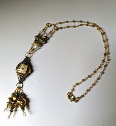 "This is a necklace made from a Bulova vintage watch dating from the 1930s. This watch is a square face with what appears to be little \"diamond\" chips above and below the face. It has an ivory face and gold hands and numerals. The watch is non-functioning  is a little piece of beautiful art! The \"tassel\" dangling from the watch is made of links using gold and silver tone beads as well as some crystal beads for a little added sparkle. Given the age of the components, there will be scratches a Bronze Vintage Charm Jewelry For Anniversary, Bronze Jewelry With Vintage Charm For Anniversary, Vintage Rectangular Locket Jewelry, Antique Jewelry With Vintage Charm And Adjustable Fit, Antique Adjustable Jewelry With Vintage Charm, Adjustable Antique Jewelry With Vintage Charm, Vintage Adjustable Locket Jewelry, Adjustable Vintage Charm Jewelry For Anniversary, Adjustable Vintage Locket Jewelry