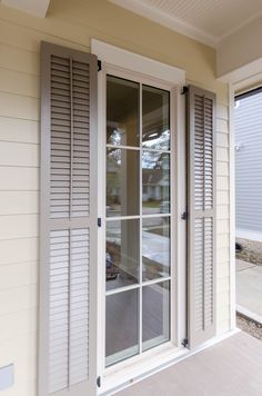 an open window on the side of a house with shutters and wood flooring