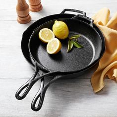 two lemons are sitting on top of a skillet