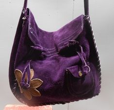 Vintage suede purse from the 1970s. Love the vibrant purple. This may have been made from a kit. Some is machine stitched and some handstitched. Has a mustard flower appliqued and a small pocket that closes with a snap. Nice long carrying strap. Condition is good with normal vintage wear. 11 x 12 in 3 in deep 31 in long with strap extended Check out my handmade clothing at kissmyattitude.etsy.com Vintage Hand-stitched Bags For Everyday Use, Vintage Hobo Shoulder Bag, Vintage Hand-stitched Bag For Daily Use, Vintage Handmade Shoulder Bag For Festivals, Vintage Purple Shoulder Bag For Daily Use, Vintage Purple Bag For Everyday Use, Vintage Hand-stitched Shoulder Bag For Festivals, Vintage Handmade Festival Bags, Vintage Purple Travel Bag