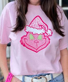 Introducing our "Pink Grinch Face Graphic Shirt," a playful and whimsical addition to your Christmas wardrobe. This shirt features a charming Grinch face in various shades of pink and is available in a wide range of sizes, from YXS to 5XL. You can choose from short sleeve, long sleeve, or sweatshirt options to match your style and comfort preferences.
The "Pink Grinch Face Graphic Shirt" offers a unique and lighthearted take on the classic Grinch character. Whether you're attending holiday parti Pink Grinch, Grinch Characters, Grinch T Shirt, Christmas Wardrobe, Grinch Face, Face Graphic, Shades Of Pink, Green Christmas, Graphic Shirt