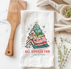 a tea towel with a christmas tree printed on it next to a wooden spatula