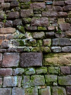 an old brick wall with moss growing on it