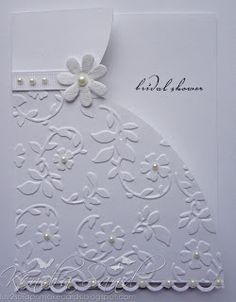 a white wedding card with flowers and pearls