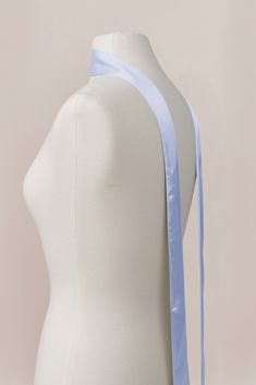 a white mannequin with a blue ribbon on it