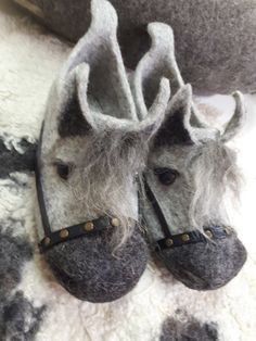 pair of slippers made to look like horses with hair on the nose and feet