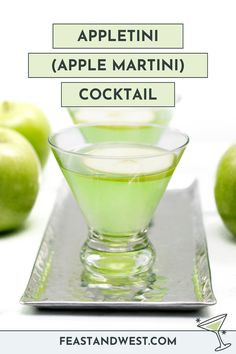 an apple martini cocktail in a glass on top of a metal tray