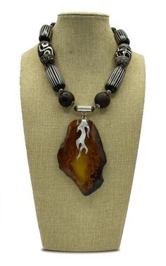 Beautifully handcrafted statement piece designed by Judy Klimek Handmade Baltic Amber Necklace In Spiritual Style, Handmade Baltic Amber Spiritual Jewelry, Handmade Baltic Amber Spiritual Necklace, Spiritual Handmade Baltic Amber Necklaces, Spiritual Handmade Baltic Amber Necklace, Amber Artisan Jewelry With Wooden Beads, Artisan Amber Jewelry With Wooden Beads, Unique Brown Resin Necklaces, Artisan Carved Amber Necklace