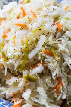 coleslaw salad with carrots, celery and onions on a blue and white plate