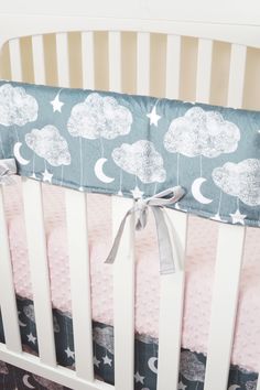 a baby crib bed with stars and clouds on it