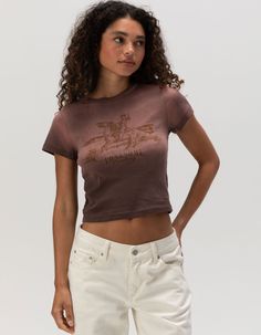 Full Tilt Lonesome Baby Tee. Large Western Graphic Screened On Front. Ribbed Crew Neckline. Short Sleeve. Acid Wash. 100% Cotton. Machine Wash. Imported. Model Is Wearing A Size Small. Model Measurements:height: 5'7" Bust: 32cwaist: 24"hips: 35" Summer Soft-washed Brown Tops, Fitted Soft-washed Crew Neck Top, Fitted Brown Crew Neck Top, Brown Cotton Y2k Top, Brown Y2k Tops With Graphic Print, Fitted Basic Soft-washed Tops, Brown Short Sleeve Y2k Top, Y2k Short Sleeve Tops For Fall, Soft-washed Fitted Basic Tops