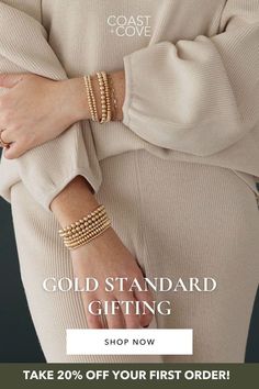 a woman wearing gold bracelets with the words, gold standard gifting shop now take 20 % off your first order