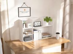 a wooden table topped with books next to a white shelf filled with books and other items