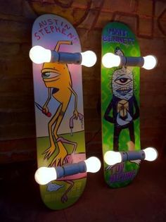 two skateboards with cartoon characters on them are lit up in the dark and one is upside down