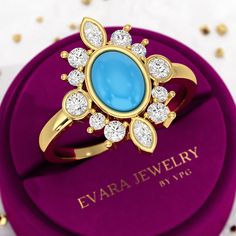 a blue stone surrounded by white diamonds sits on top of a purple velvet box with gold trimmings