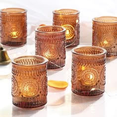 several glass candles are lined up on a table