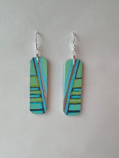 This pair of Mary Bea Art hand painted earrings is completely unique. They are hand crafted by the artist from painted birchwood, sterling silver, and 14k gold. They are durable, comfortable, non-allergenic, and lightweight. Enjoy this piece of wearable art for years to come. Artistic Hand Painted Turquoise Jewelry, Unique Hand Painted Metal Earrings, Artsy Hand Painted Green Jewelry, Artsy Hand Painted Silver Earrings, Unique Hand Painted Turquoise Earrings, Artistic Hand-painted Turquoise Jewelry, Artsy Hand Painted Green Earrings, Hand Painted Artsy Turquoise Earrings, Green Hand Painted Artsy Earrings