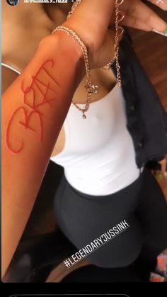 a woman is showing off her arm with the word crazy on it's side