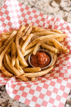 french fries with ketchup in a basket on a table